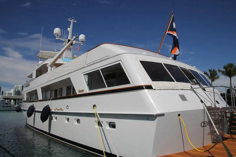 a white boat with a flag on it aboard SYNTHESIS 66 Yacht for Sale
