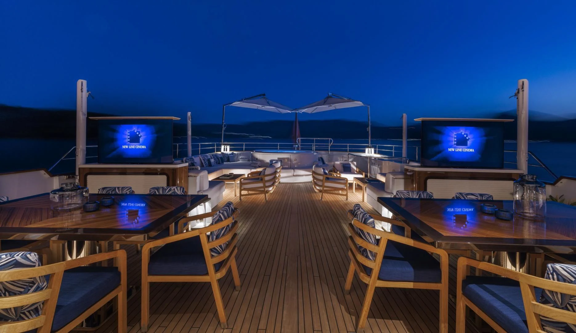 a deck with a table and chairs and a television on the roof aboard SYNTHESIS 66 Yacht for Sale