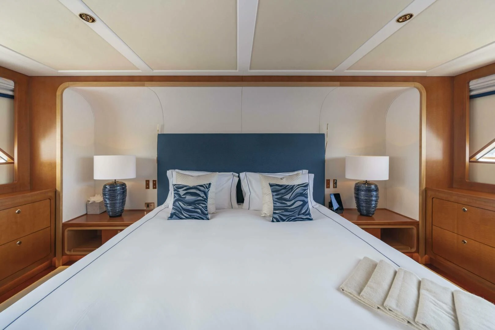 a bed with blue sheets aboard SYNTHESIS 66 Yacht for Sale