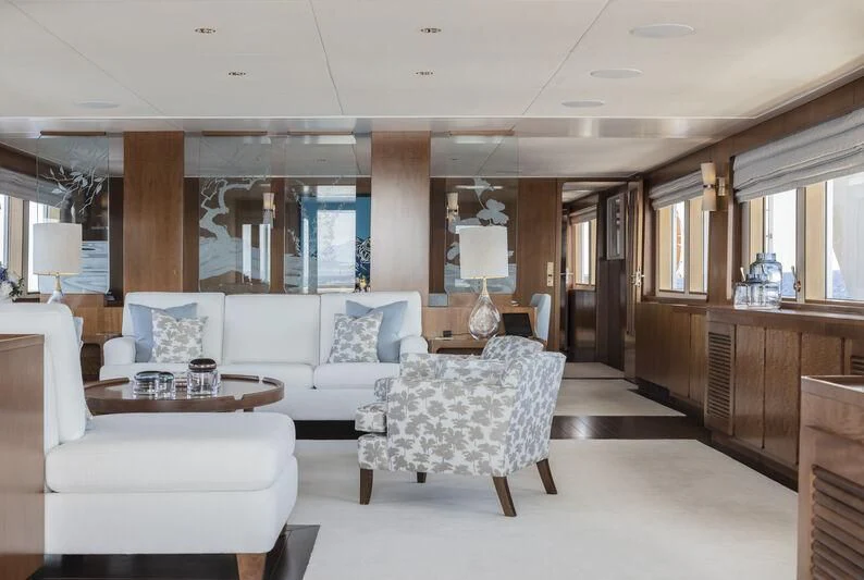 a living room with a large white couch and a large window aboard SYNTHESIS 66 Yacht for Sale