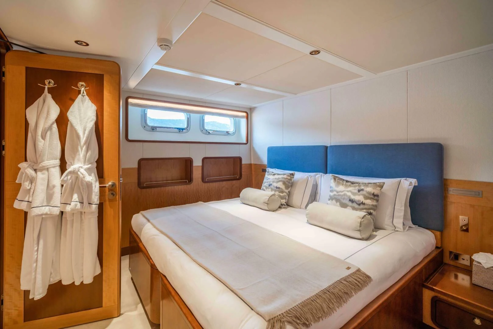 a bedroom with a bed and a robe aboard SYNTHESIS 66 Yacht for Sale