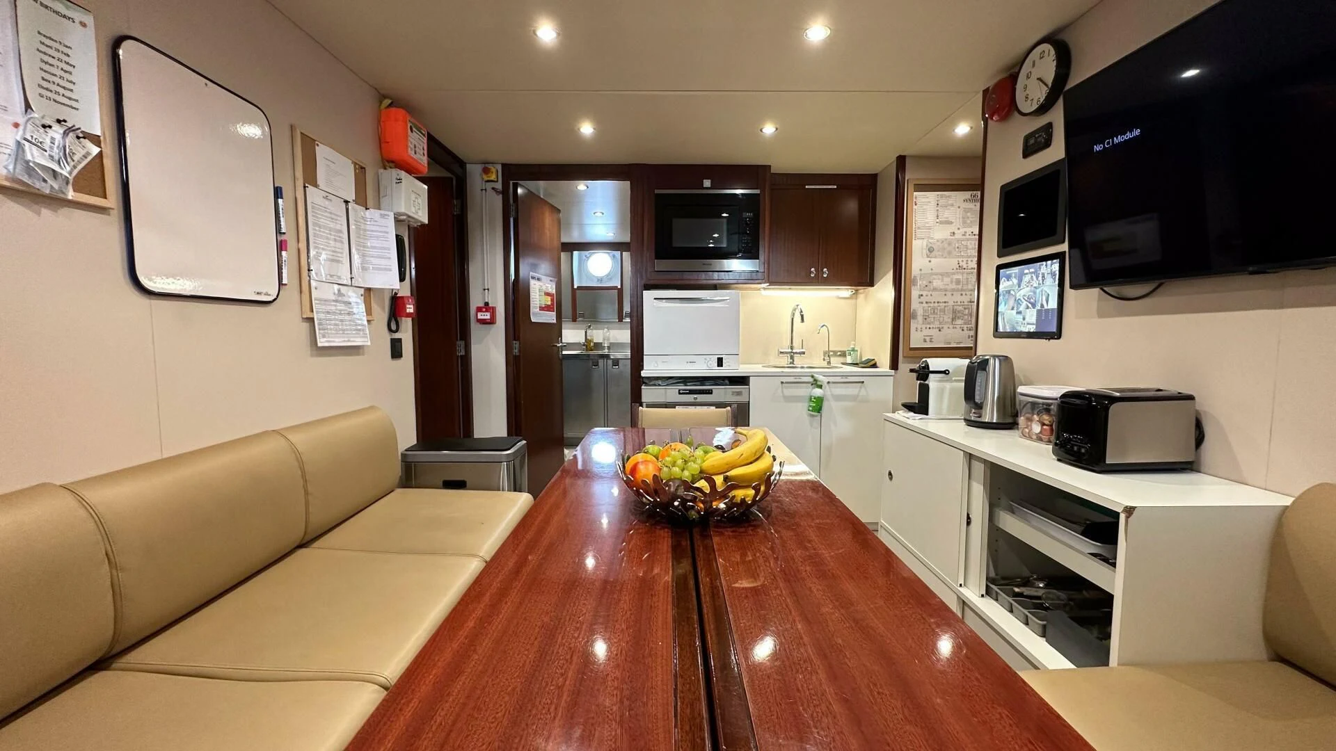 a kitchen with a table and a couch aboard SYNTHESIS 66 Yacht for Sale