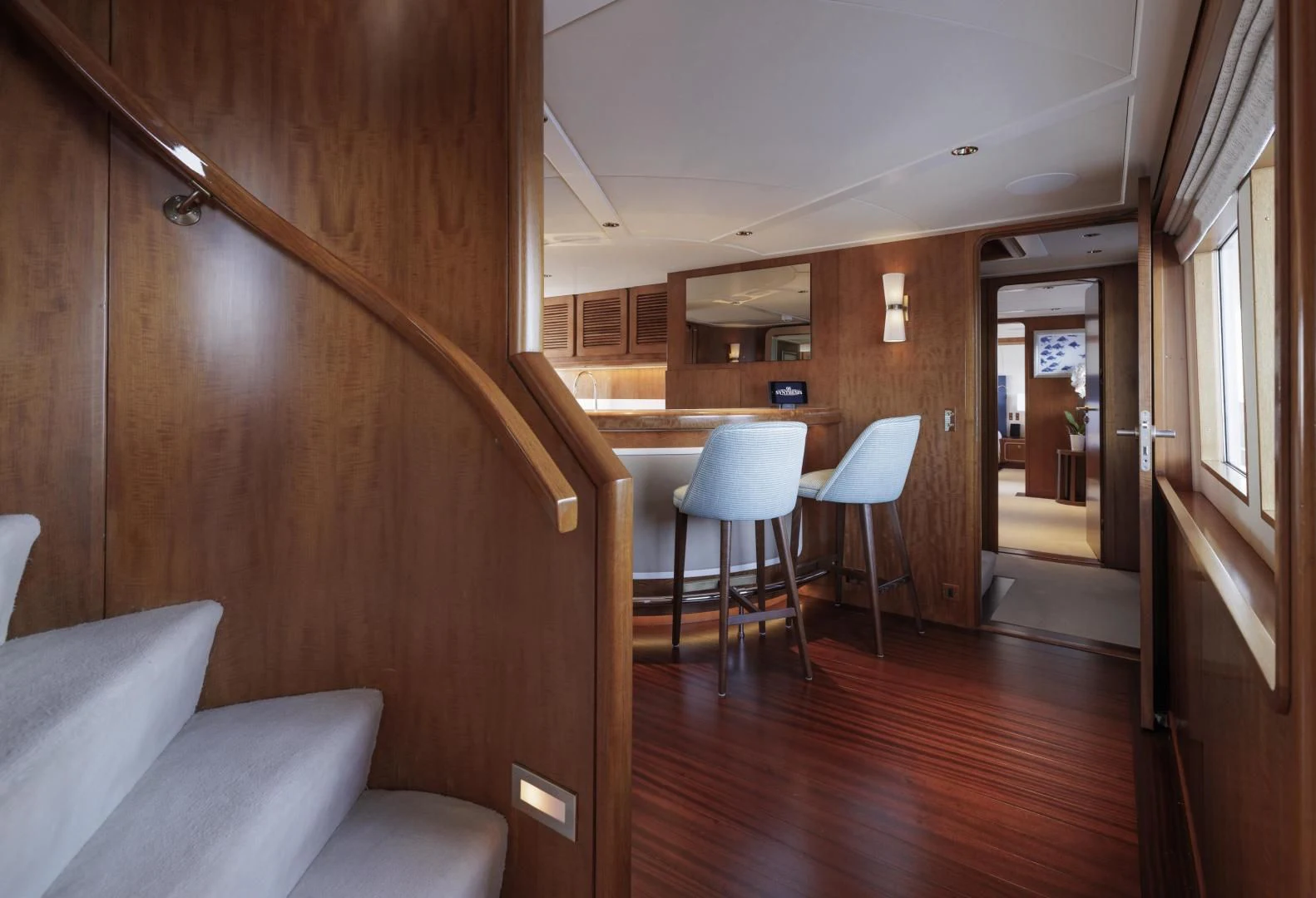 a room with a wood floor and chairs and a wood door aboard SYNTHESIS 66 Yacht for Sale