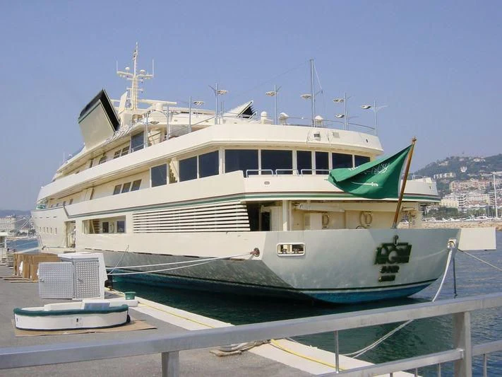 a large white boat with a green flag on it aboard KINGDOM 5KR Yacht for Sale