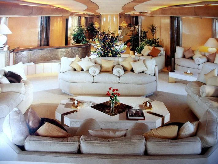 a living room with a large white couch and a large fireplace aboard KINGDOM 5KR Yacht for Sale