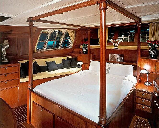 a bed with a wooden frame aboard DOLPHIN Yacht for Sale
