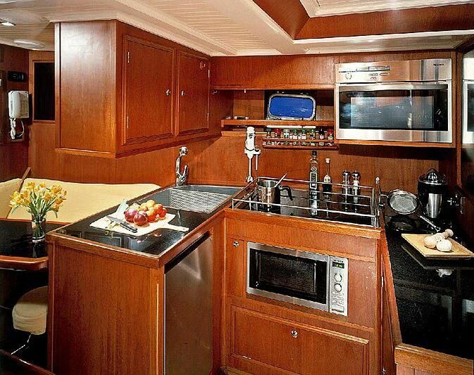 a kitchen with wooden cabinets aboard DOLPHIN Yacht for Sale