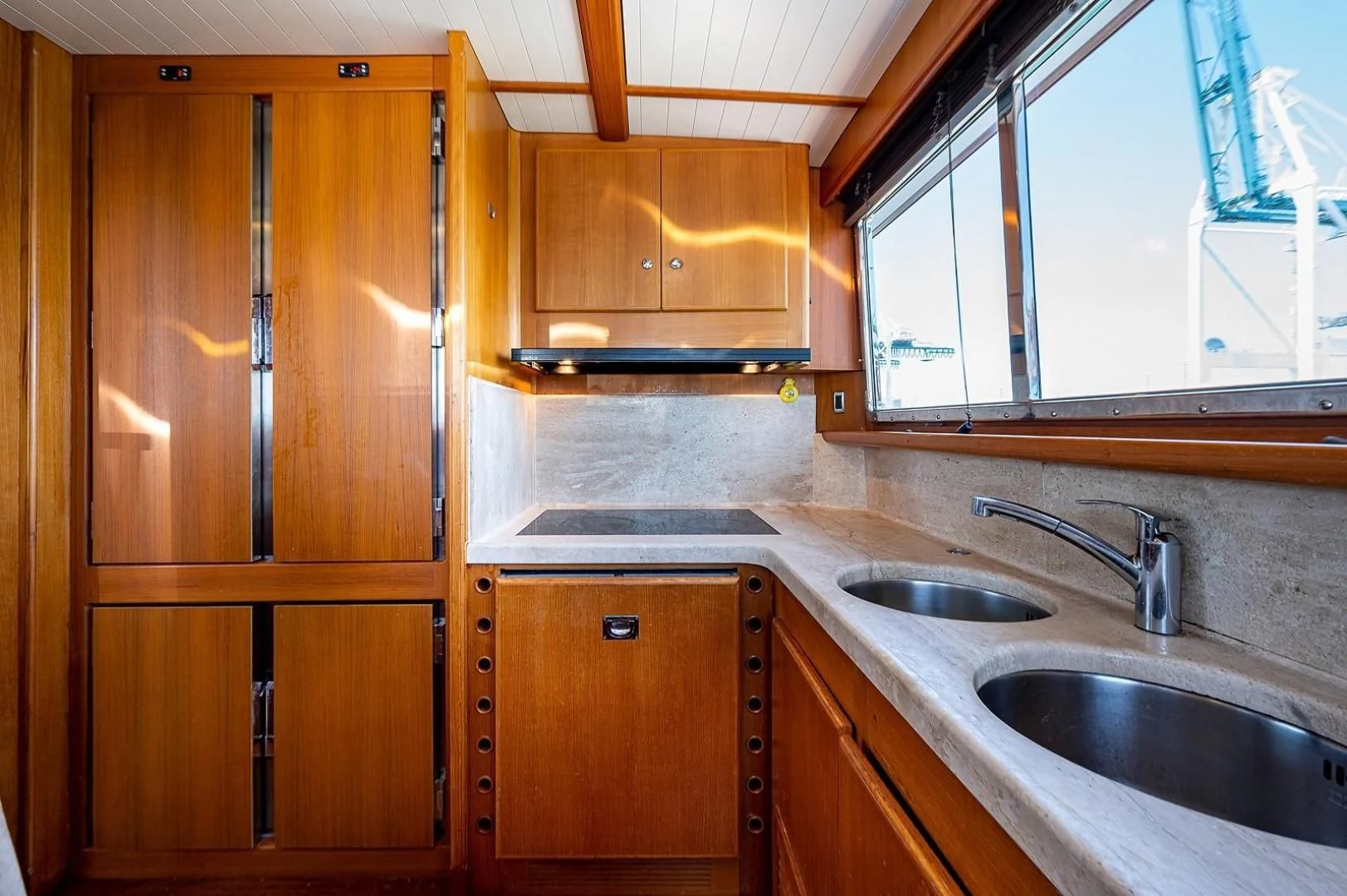 a kitchen with wooden cabinets aboard ATALI Yacht for Sale