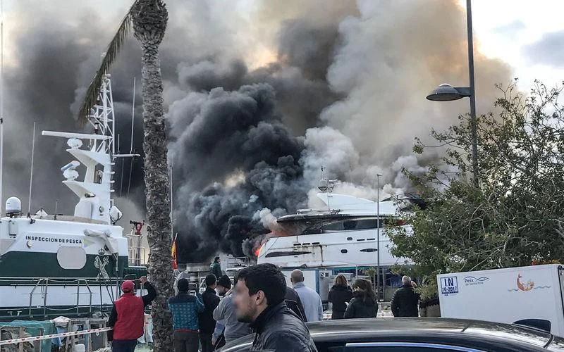 a group of people watching a large fire aboard ORDISI Yacht for Sale