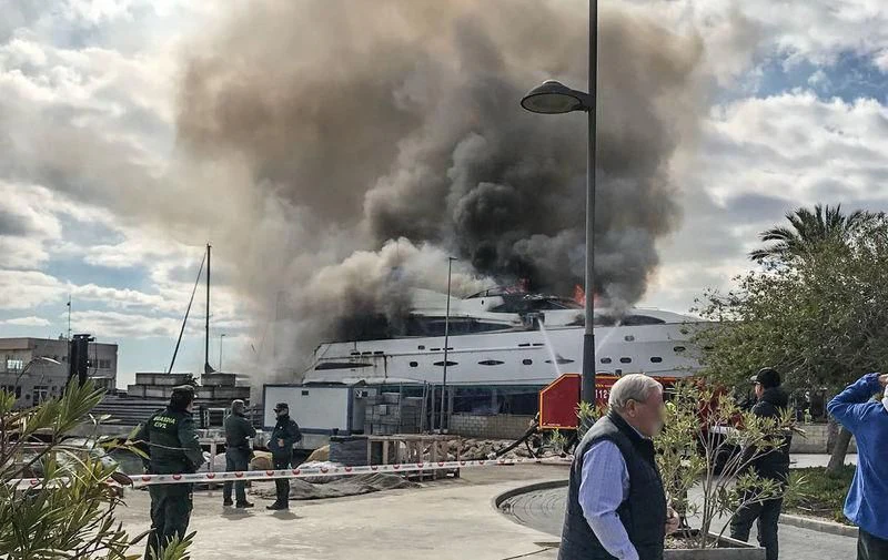 a group of people standing next to a large building on fire aboard ORDISI Yacht for Sale