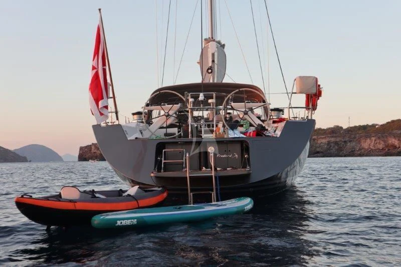 a boat with a flag on the front aboard FREEBIRD Yacht for Sale