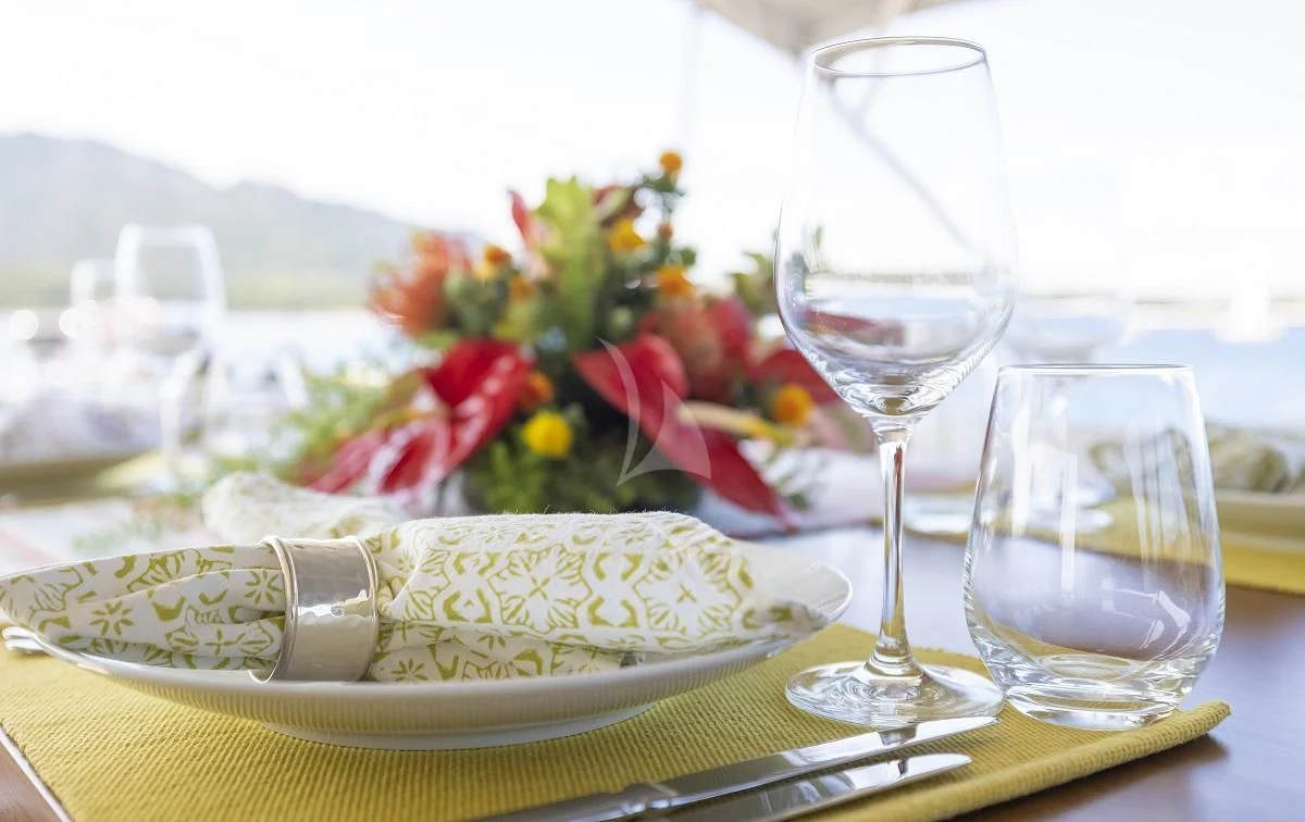 a plate of food and glasses aboard FREEBIRD Yacht for Sale