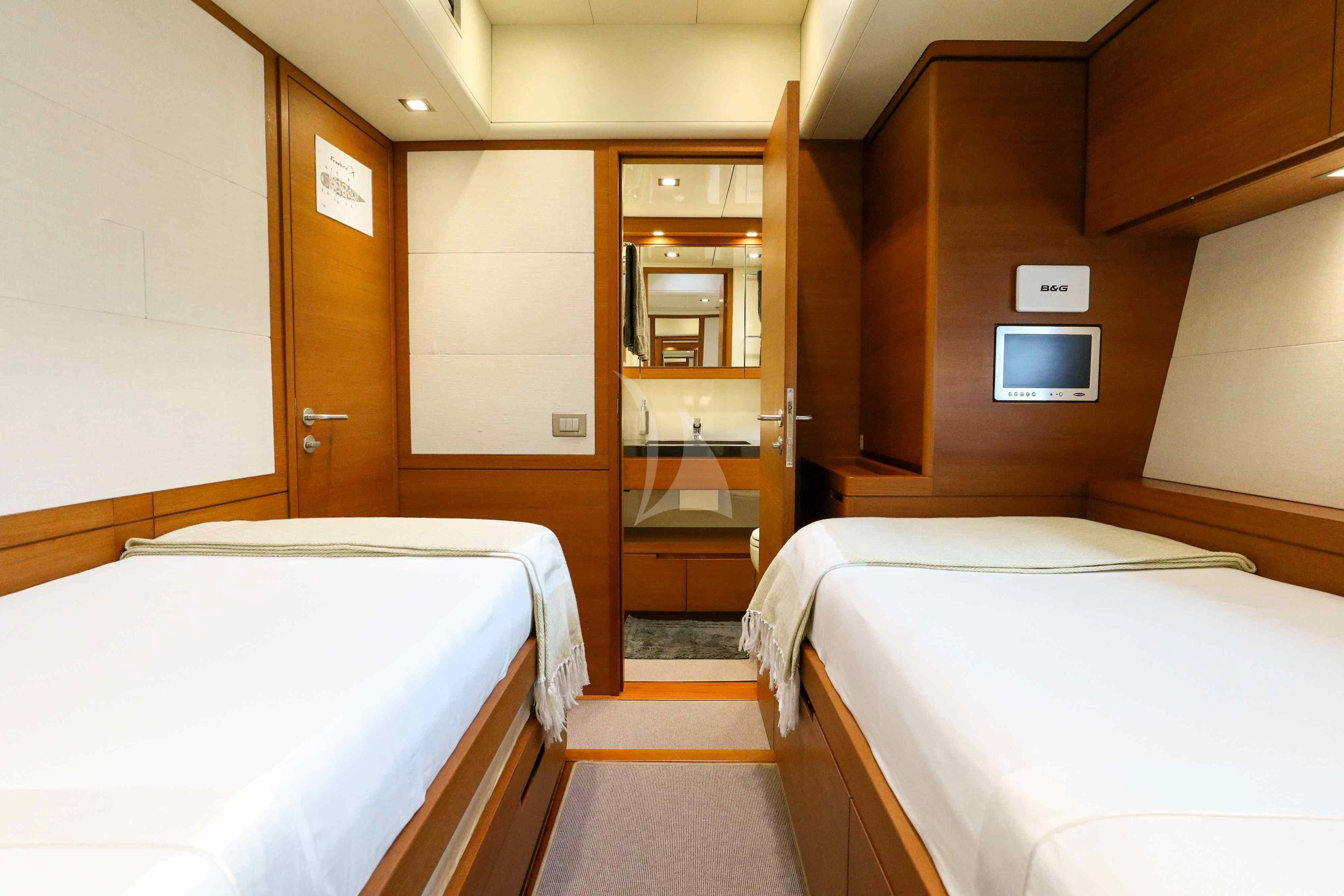 a room with beds and a mirror aboard FREEBIRD Yacht for Sale
