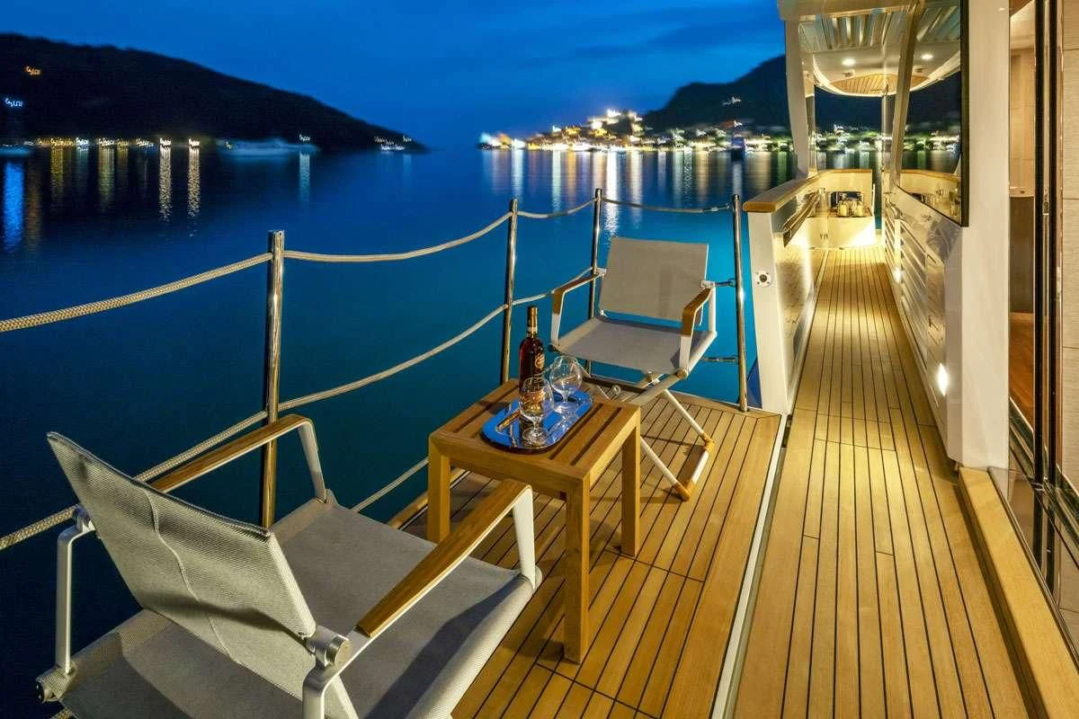 a deck with a table and chairs on it aboard ANYTHING GOES V Yacht for Sale