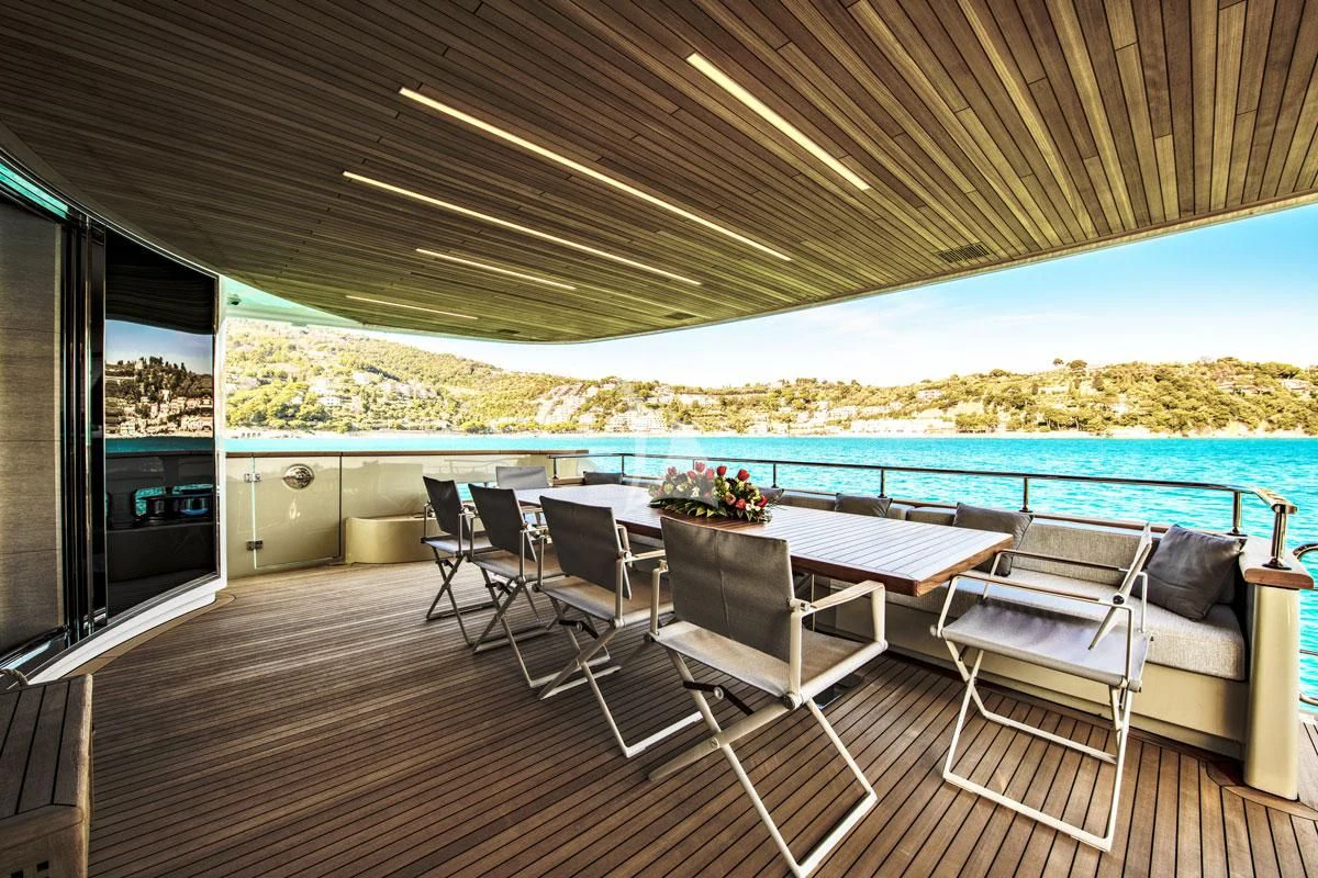 a deck with a table and chairs on it aboard ANYTHING GOES V Yacht for Sale