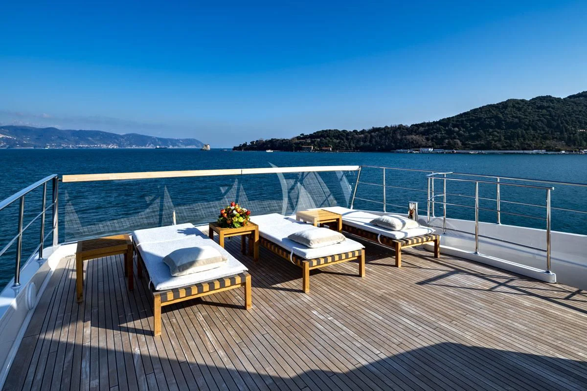a table and chairs on a deck overlooking a body of water aboard ANYTHING GOES V Yacht for Sale