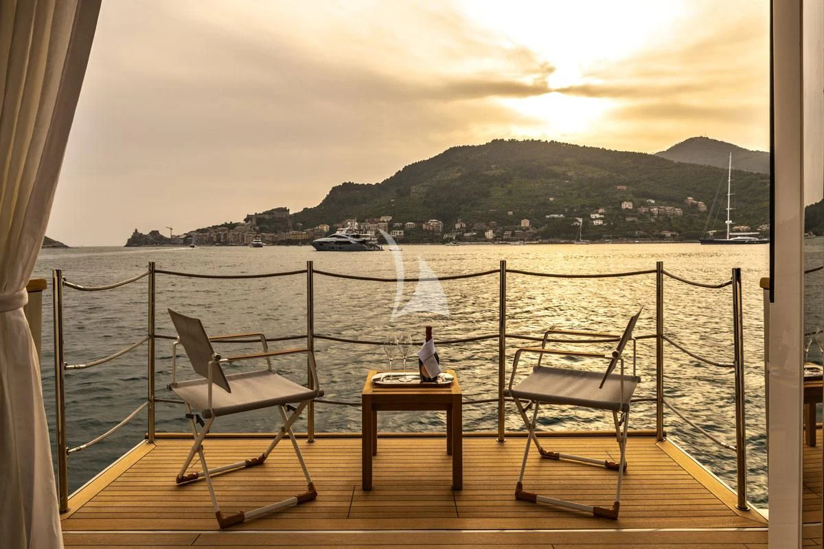 a person sitting on a chair on a dock by a body of water aboard ANYTHING GOES V Yacht for Sale