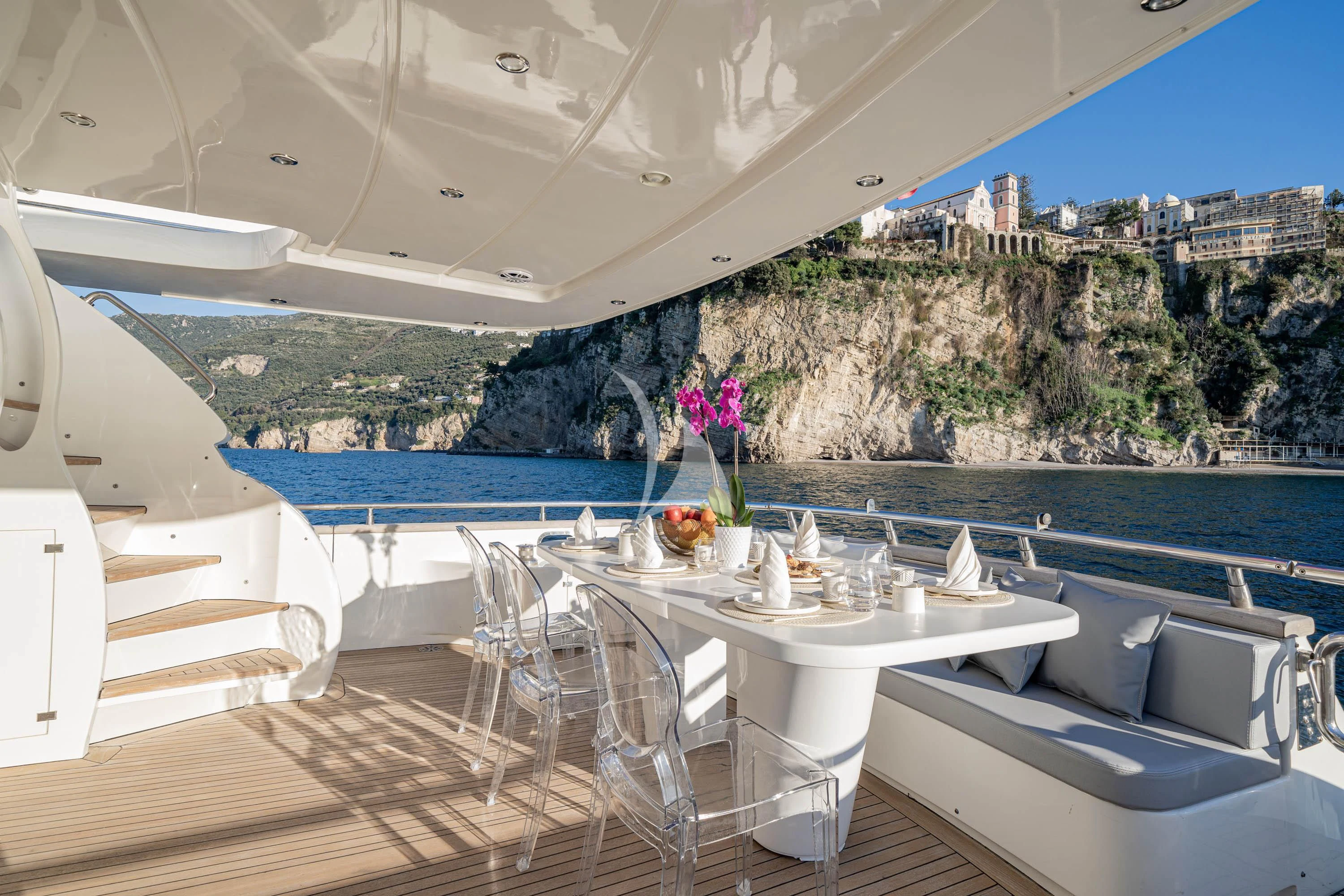 a table with chairs on it next to a large body of water aboard GEMINI 3 Yacht for Charter