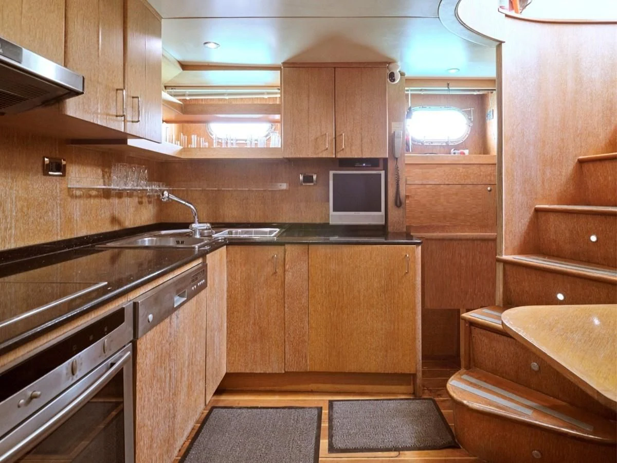 a kitchen with wooden cabinets aboard HUNTING STAR Yacht for Sale