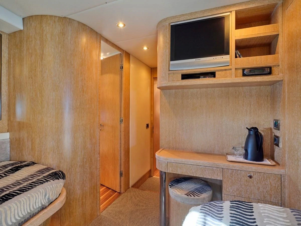a room with a tv and a table aboard HUNTING STAR Yacht for Sale