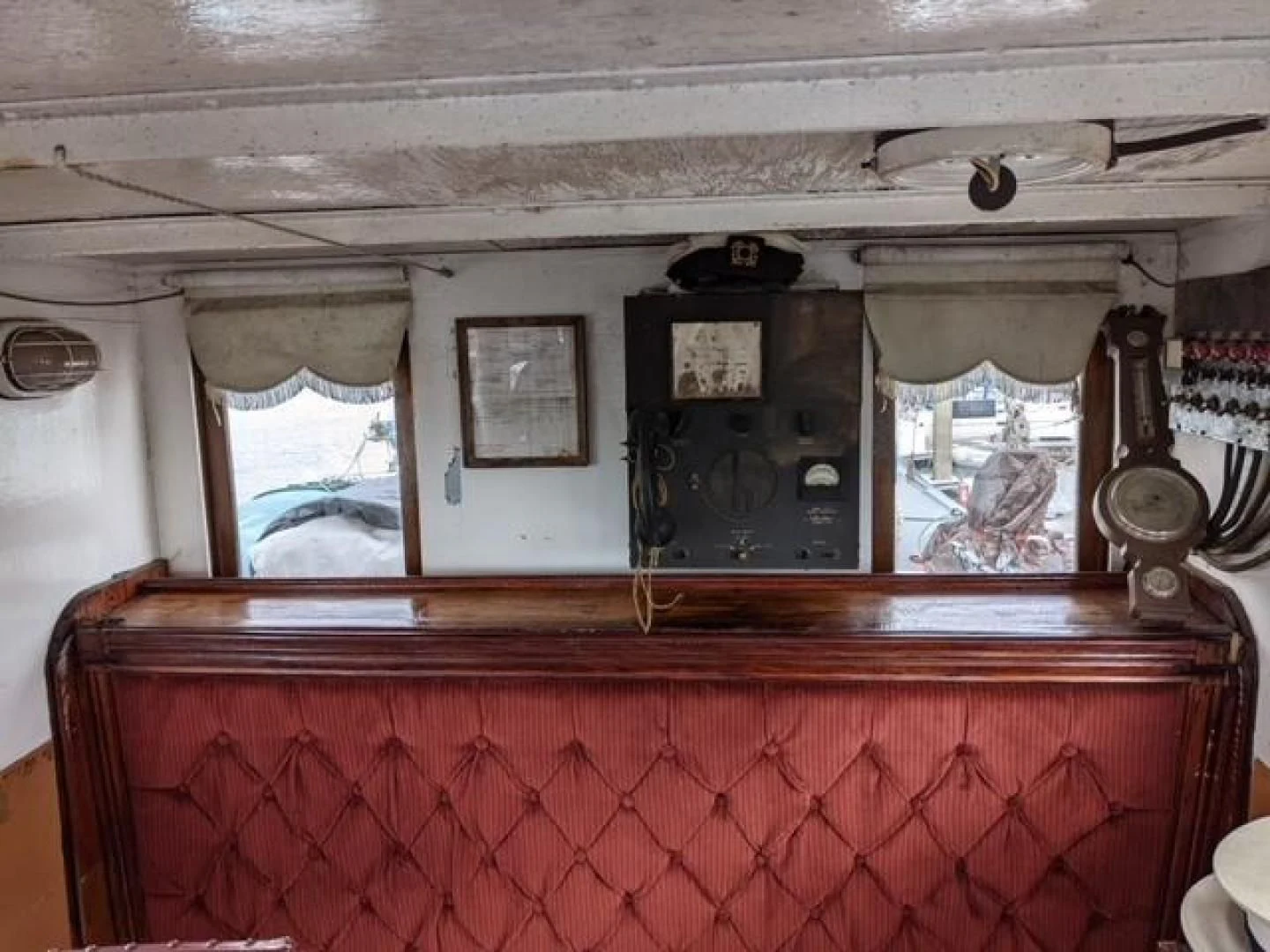 a room with a red wall and a window with a mirror aboard EL PRIMERO Yacht for Sale