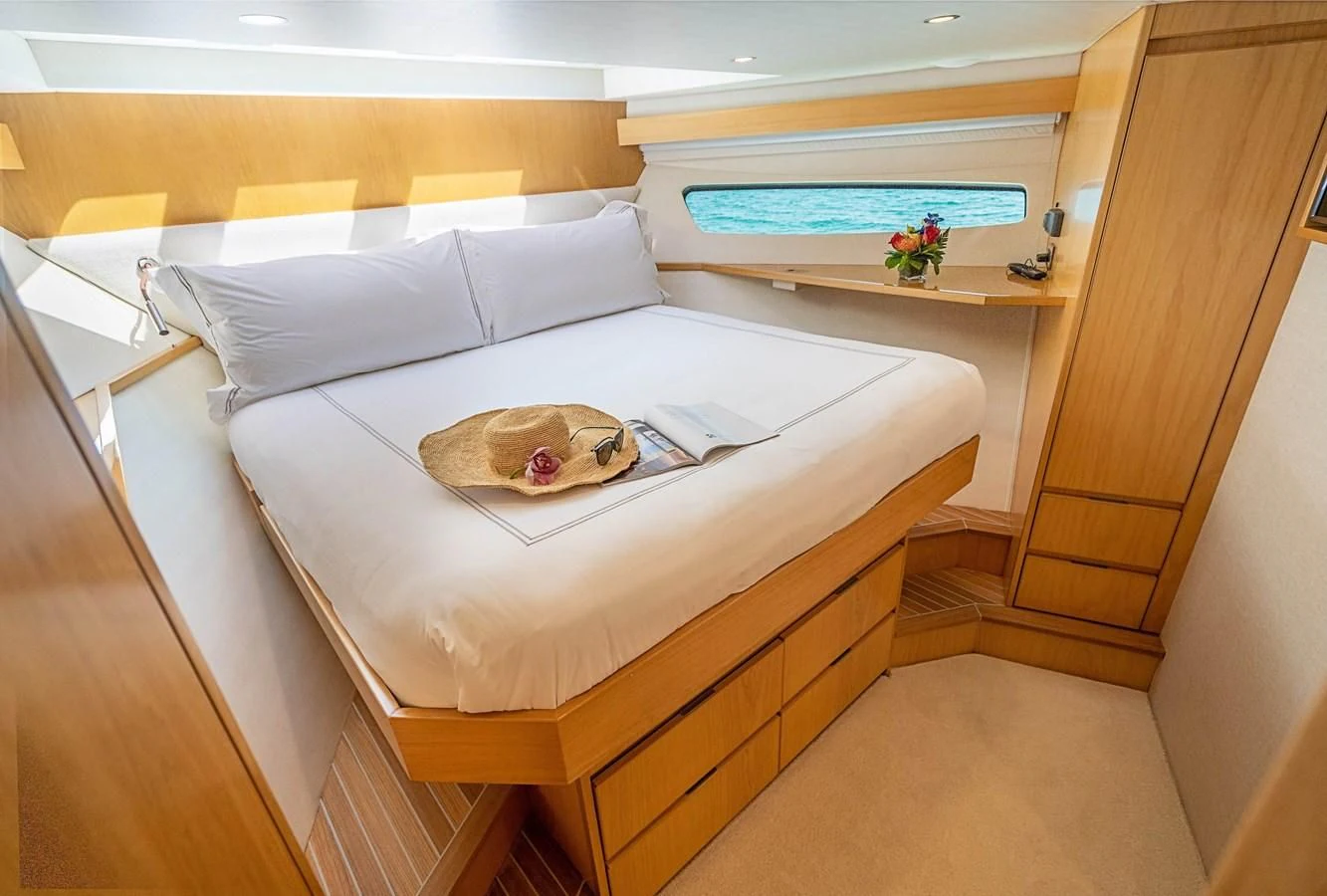 a bed with a white sheet and a white pillow on it aboard MARYBELLE Yacht for Sale