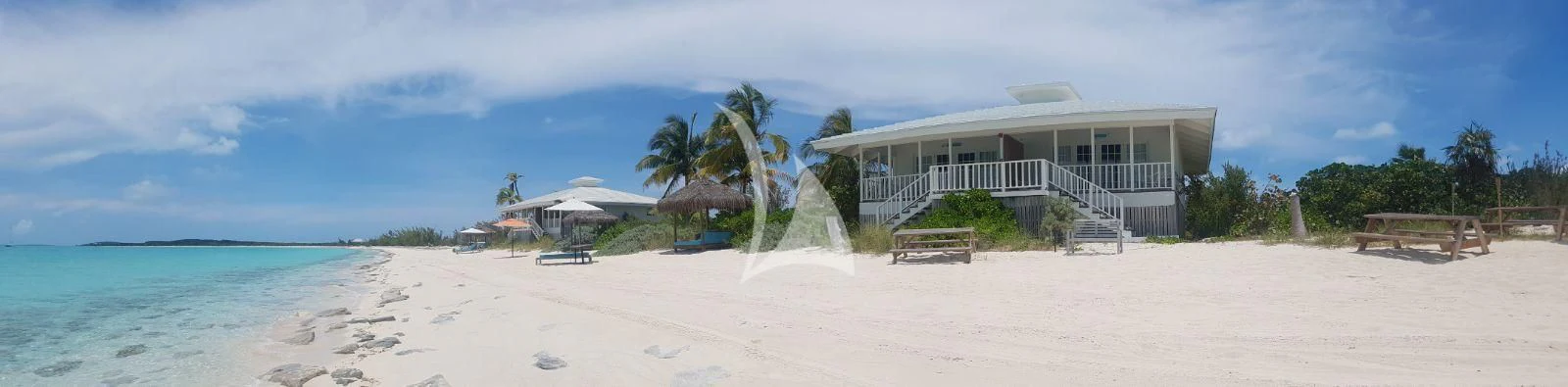 a beach with a building and trees aboard MARYBELLE Yacht for Sale