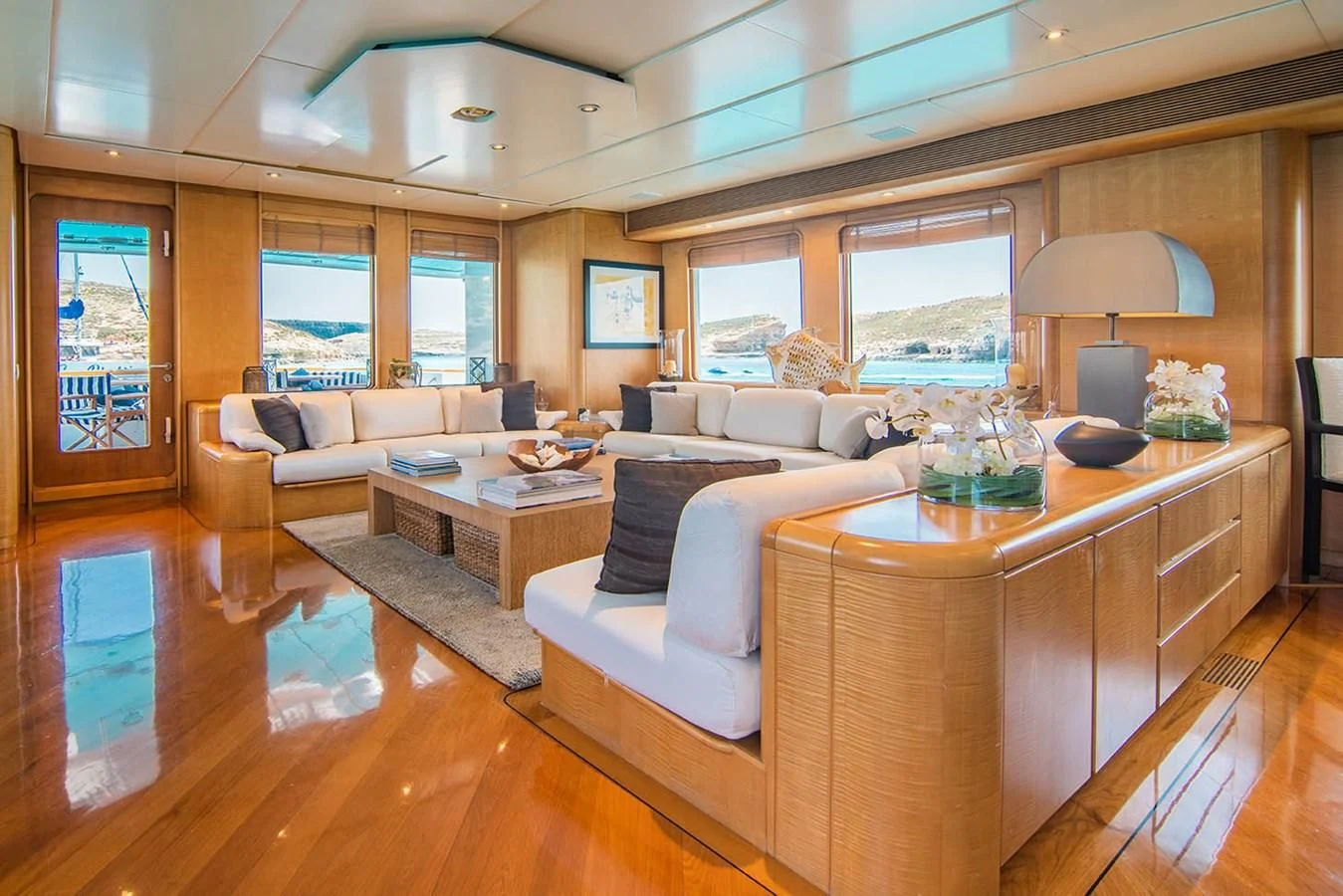 a living room with a large wood table and a large window aboard CRISS C Yacht for Sale