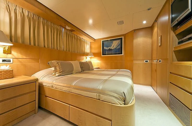 a bedroom with a bed and a tv aboard CRISS C Yacht for Sale