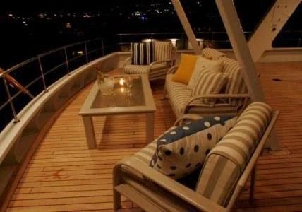 a deck with chairs and a table aboard AURORA Yacht for Charter