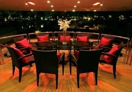 a group of chairs and tables in a room with a large window aboard AURORA Yacht for Charter