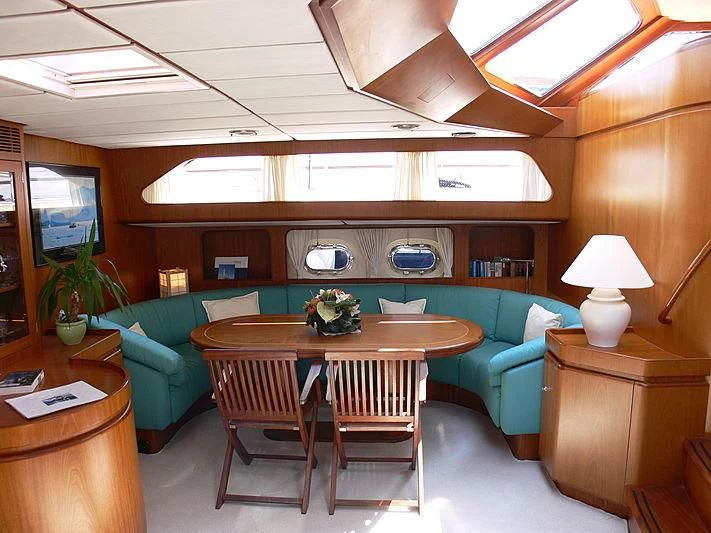 a living room with a blue couch and a table aboard BLACK MOLLY Yacht for Sale