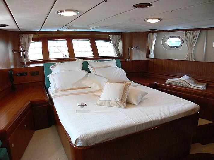 a room with a bed and a window aboard BLACK MOLLY Yacht for Sale