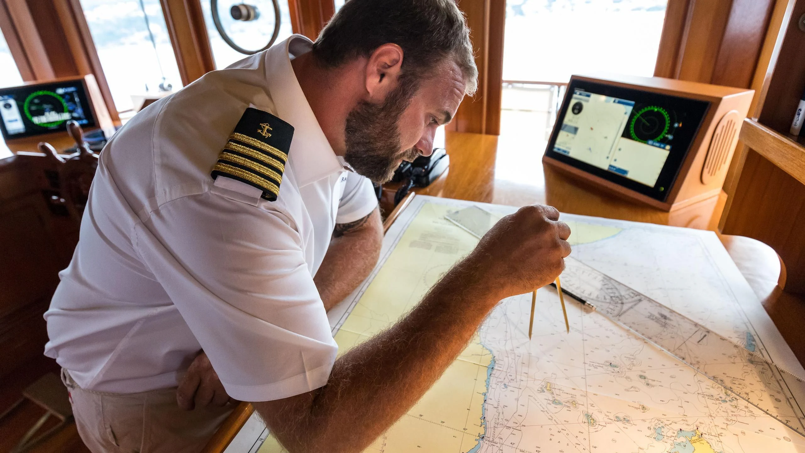 a man showing a piece of paper to a man aboard OVER THE RAINBOW OF LONDON Yacht for Charter