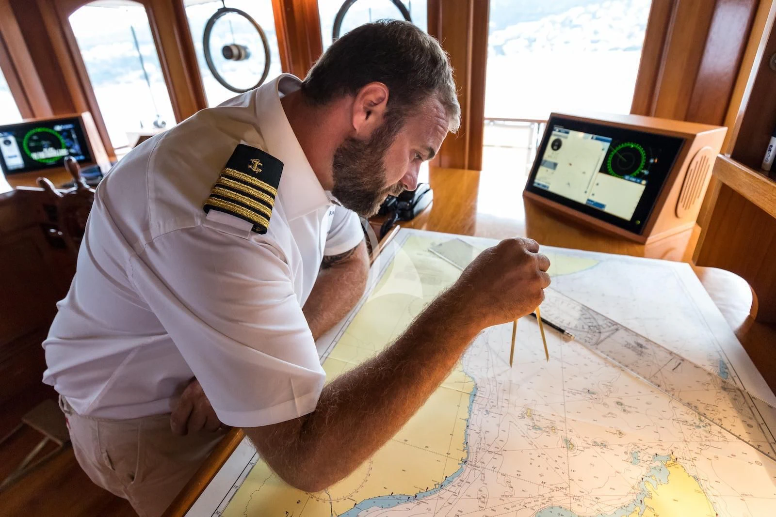 a man looking at a map aboard OVER THE RAINBOW OF LONDON Yacht for Charter