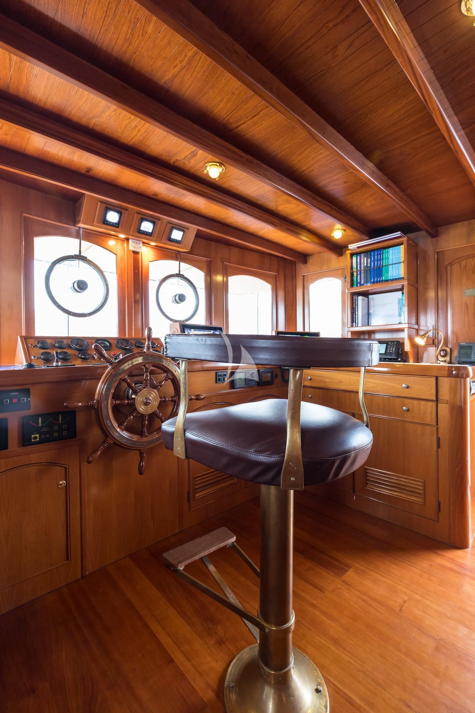 a room with a bar and stools and a large fan aboard OVER THE RAINBOW OF LONDON Yacht for Charter