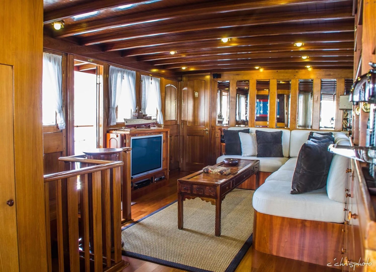 a living room with a couch and a television aboard OVER THE RAINBOW OF LONDON Yacht for Charter