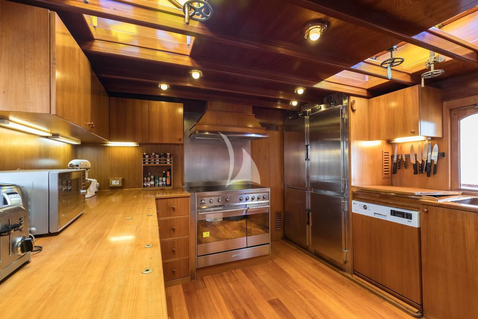 a kitchen with wooden cabinets aboard OVER THE RAINBOW OF LONDON Yacht for Charter
