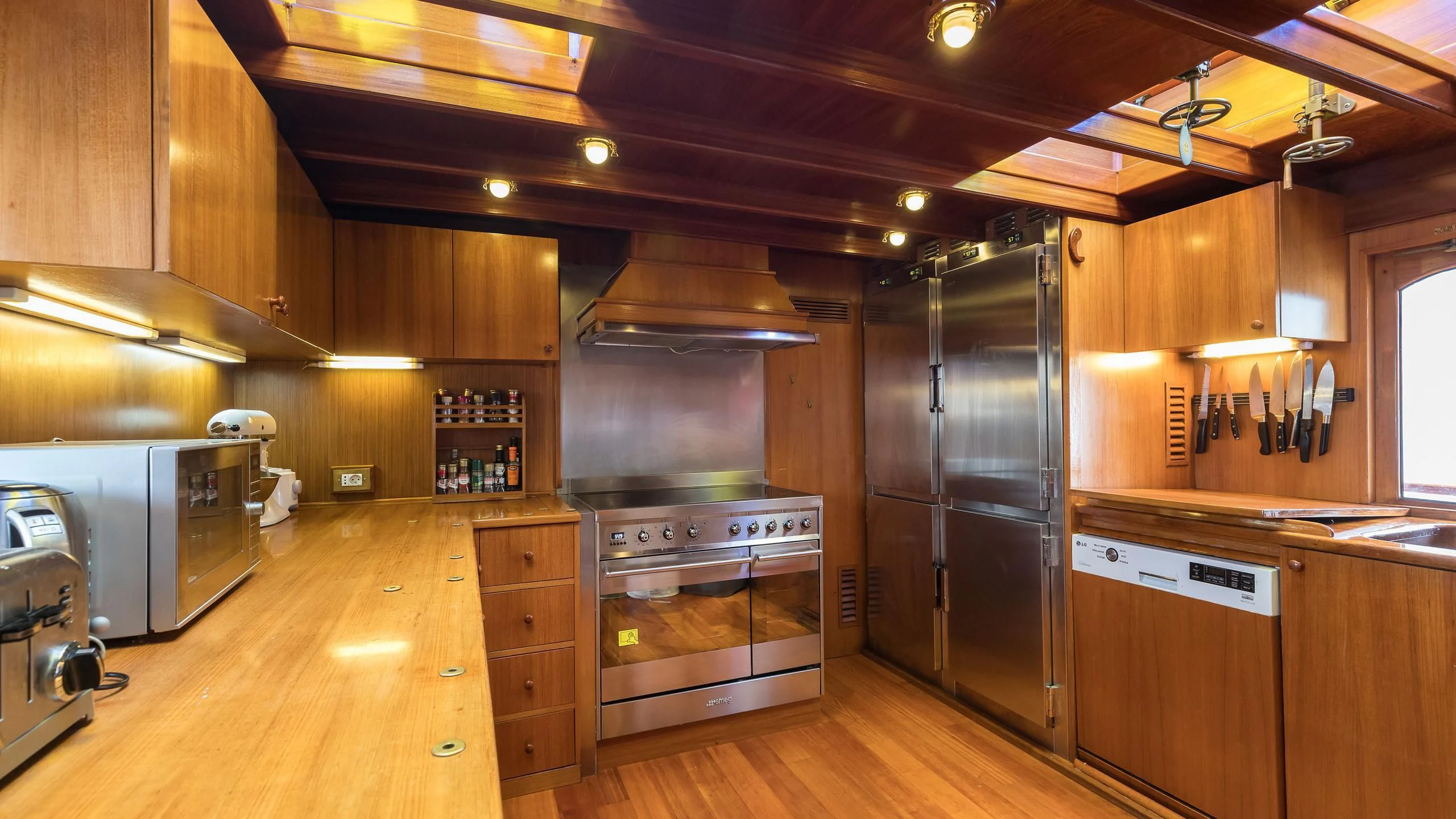 a kitchen with wooden cabinets aboard OVER THE RAINBOW OF LONDON Yacht for Charter