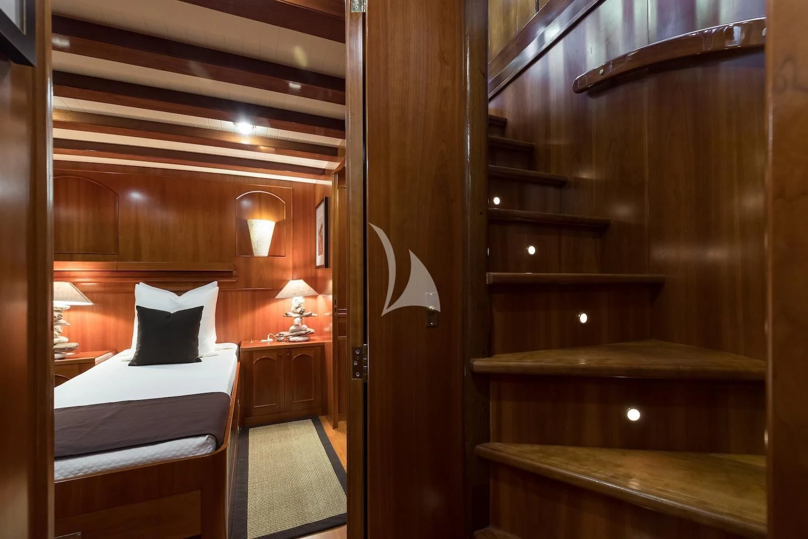 a room with a bed and a table aboard OVER THE RAINBOW OF LONDON Yacht for Charter