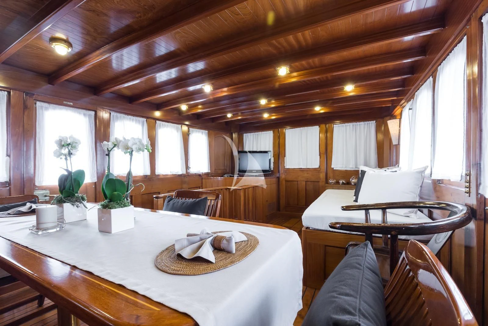 a table with chairs and a large window aboard OVER THE RAINBOW OF LONDON Yacht for Charter