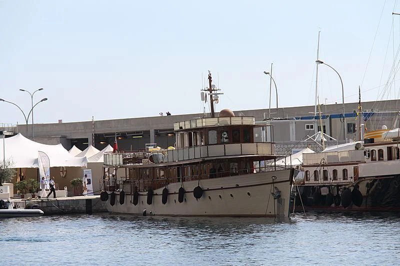 a large boat docked at a pier aboard OVER THE RAINBOW OF LONDON Yacht for Charter