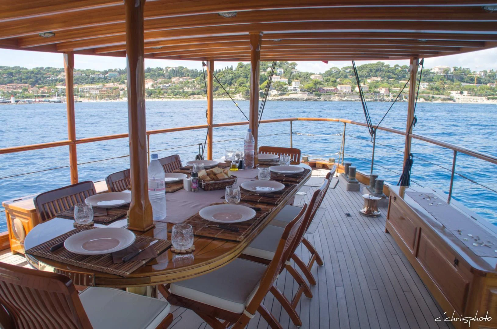 a table set for a meal on a deck overlooking a body of water aboard OVER THE RAINBOW OF LONDON Yacht for Charter