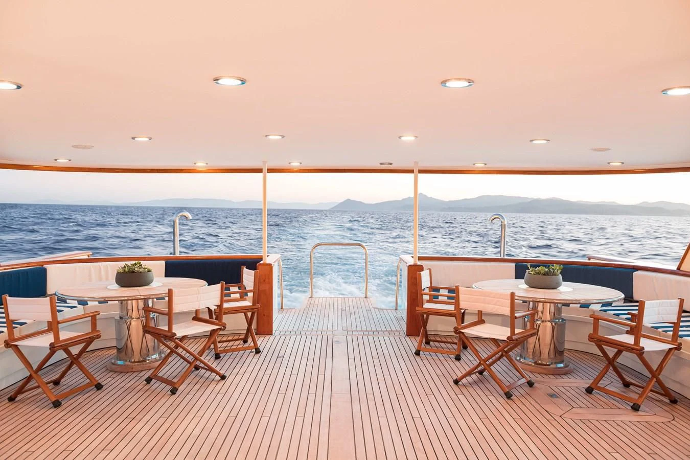 a deck with tables and chairs aboard WIND OF FORTUNE Yacht for Charter