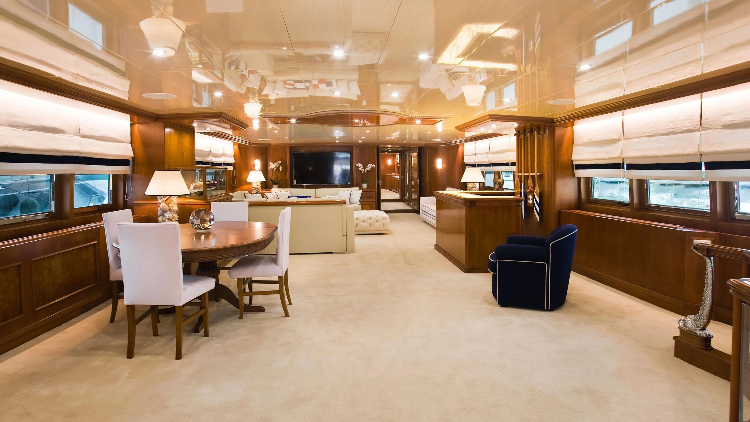 a large room with a table and chairs aboard WIND OF FORTUNE Yacht for Charter