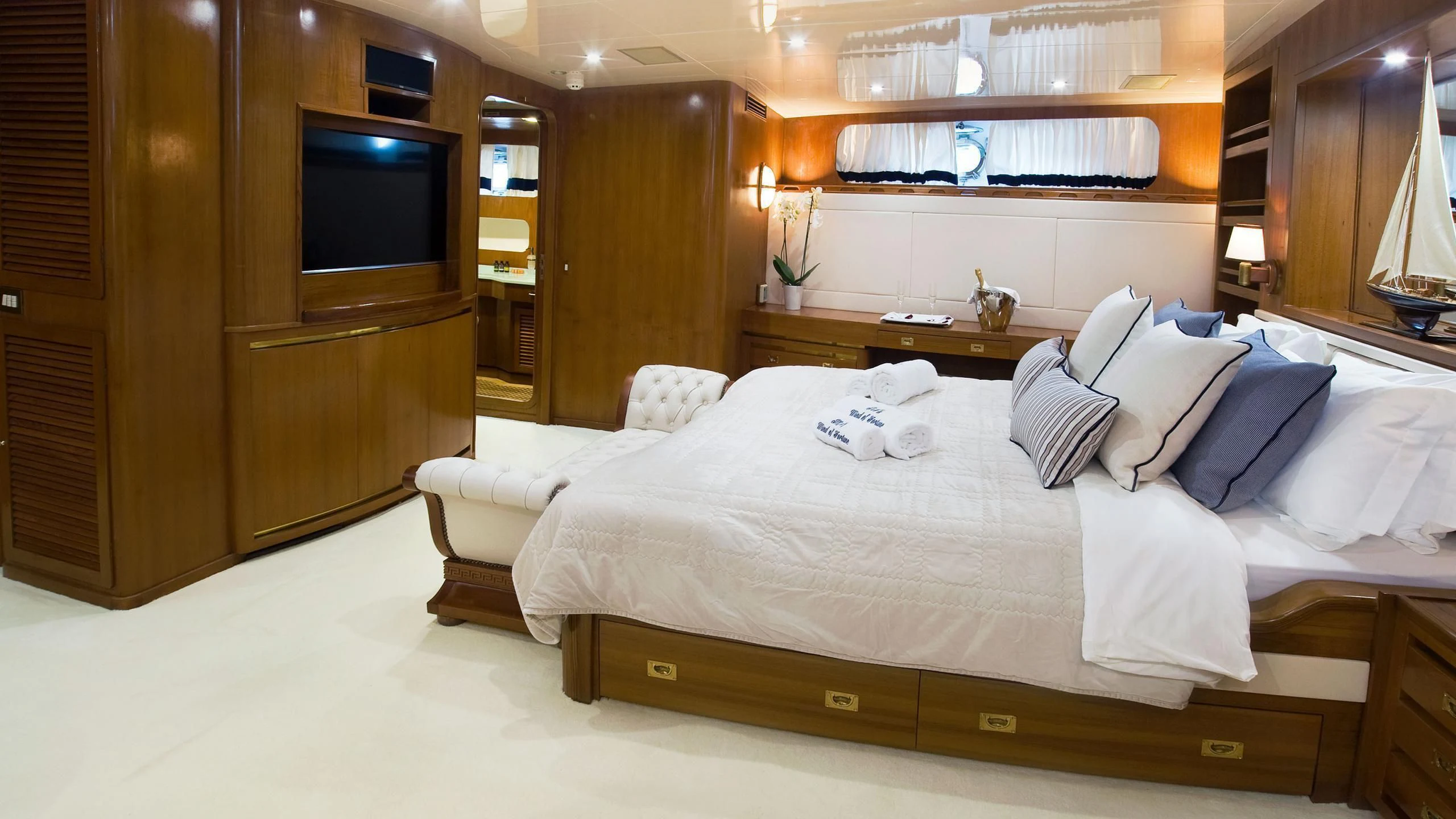 a hotel room with a bed and tv aboard WIND OF FORTUNE Yacht for Charter