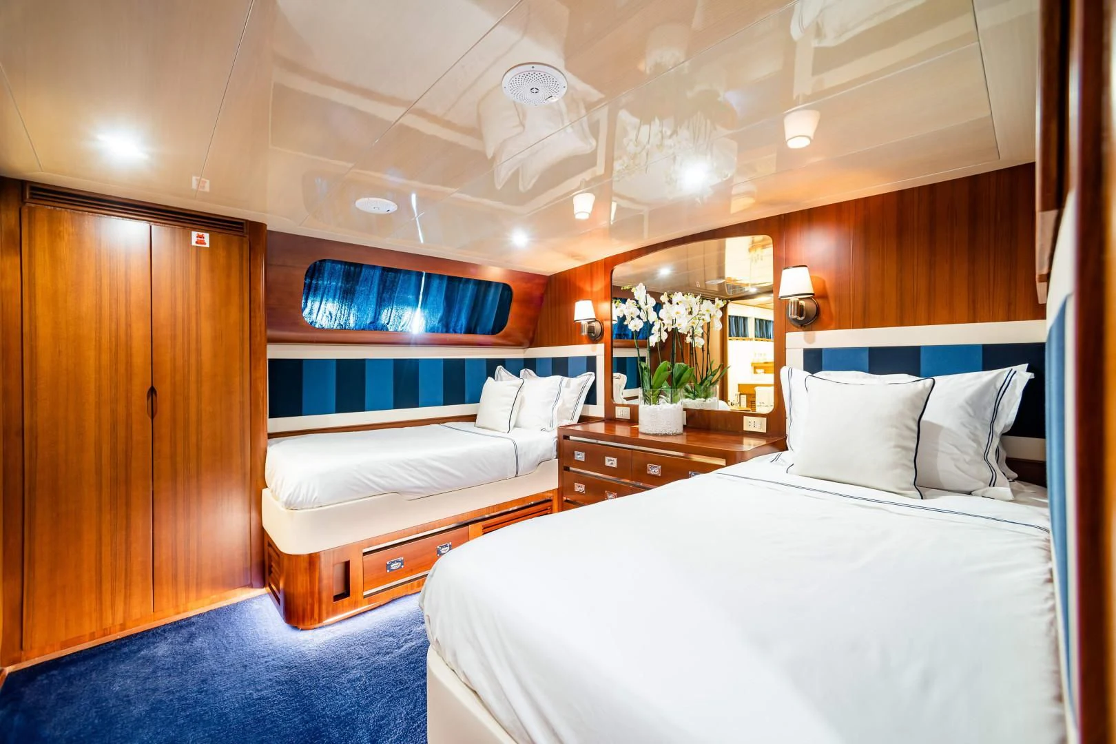 a room with a bed and a mirror aboard WIND OF FORTUNE Yacht for Charter