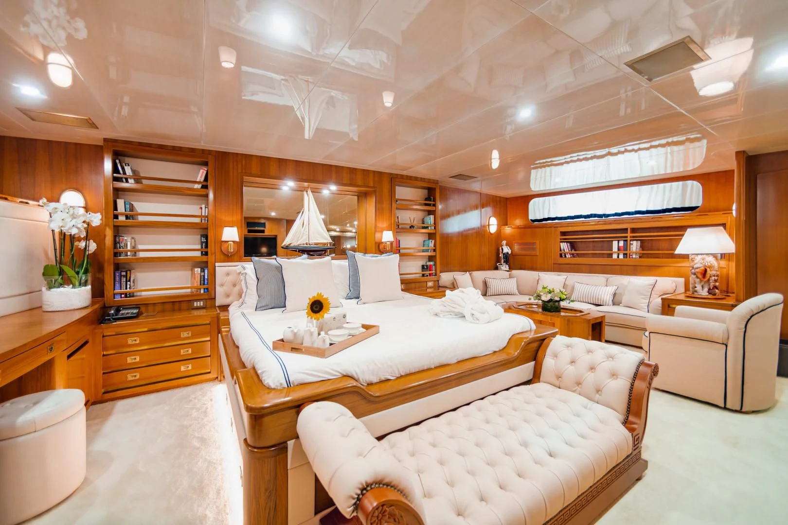 a large living room with a large bed and a bookcase aboard WIND OF FORTUNE Yacht for Charter