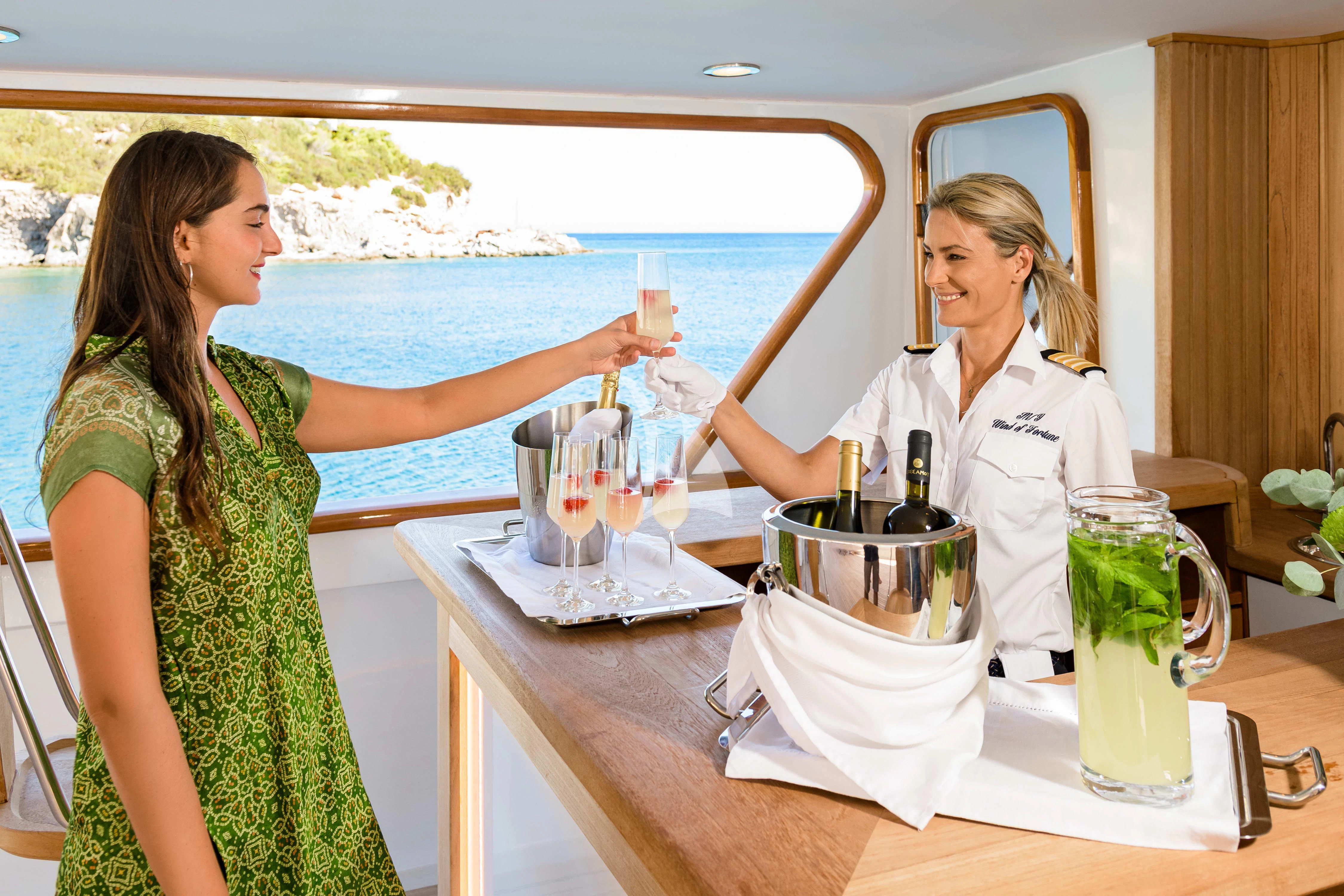 a couple of women pouring drinks aboard WIND OF FORTUNE Yacht for Charter