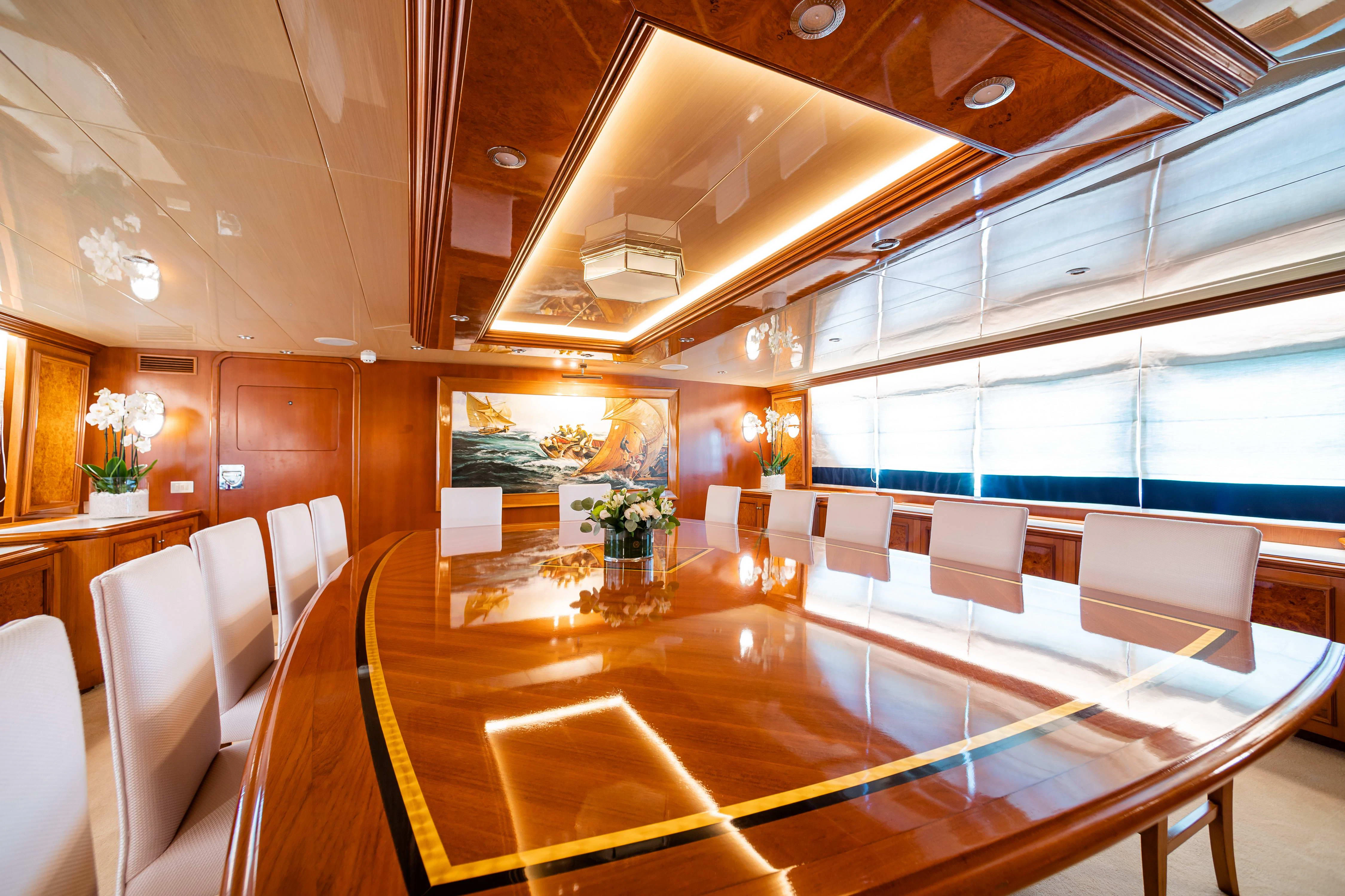 a room with a large table and chairs aboard WIND OF FORTUNE Yacht for Charter